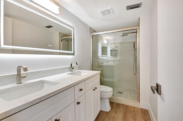 bathroom with visible vents, a sink, toilet, and a shower stall