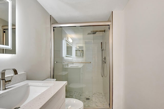 full bathroom with toilet, a shower stall, and vanity