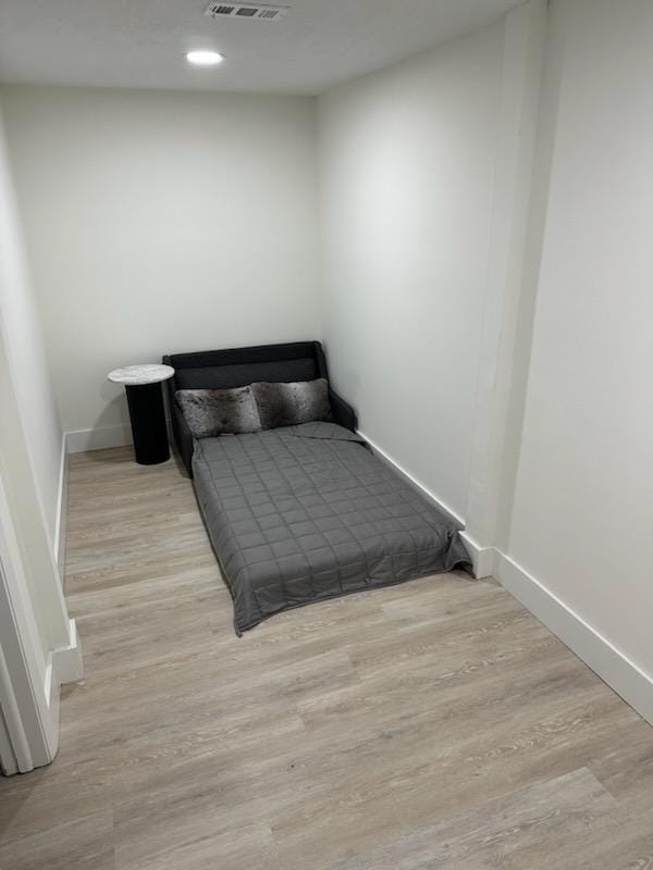 bedroom with visible vents, baseboards, and wood finished floors