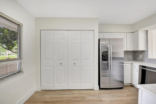 kitchen featuring light wood-style flooring, white cabinetry, dishwasher, and stainless steel refrigerator with ice dispenser