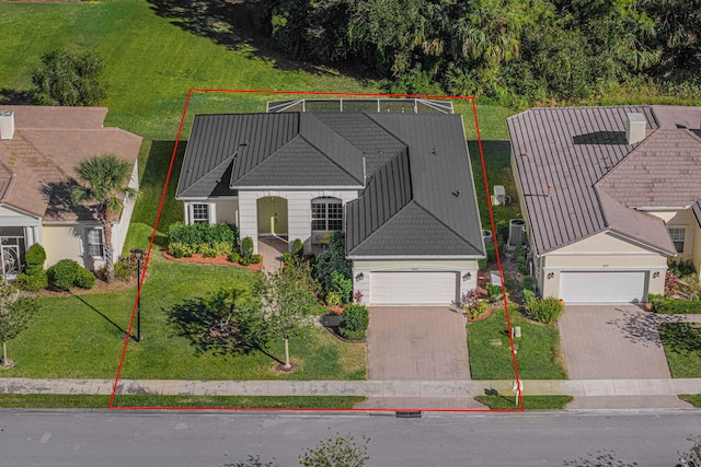 exterior space with a garage, decorative driveway, a front yard, and a tile roof