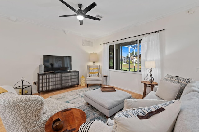 living area with baseboards, a ceiling fan, visible vents, and crown molding