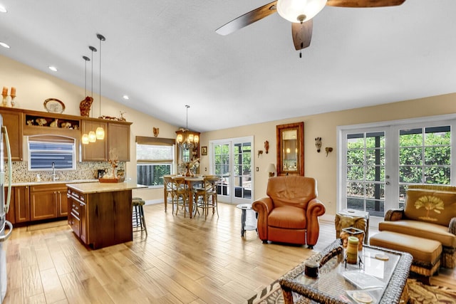 interior space with french doors, lofted ceiling, recessed lighting, light wood-style flooring, and ceiling fan with notable chandelier