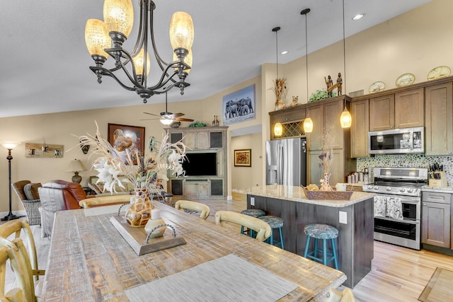 dining room featuring high vaulted ceiling, a ceiling fan, and light wood-style floors