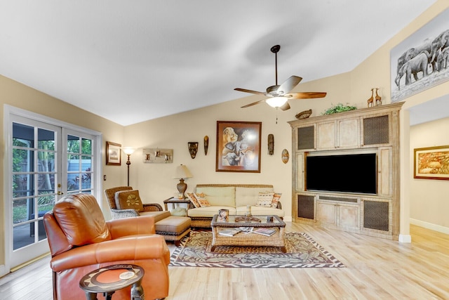 living area with light wood-style flooring, a ceiling fan, baseboards, vaulted ceiling, and french doors