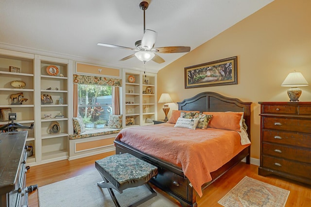 bedroom featuring lofted ceiling, ceiling fan, wood finished floors, and baseboards