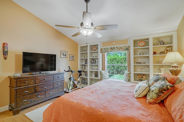 bedroom featuring a ceiling fan, vaulted ceiling, baseboards, and wood finished floors