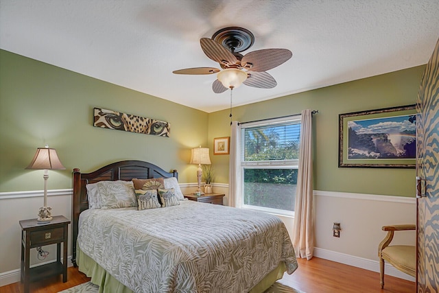 bedroom with ceiling fan, baseboards, and wood finished floors