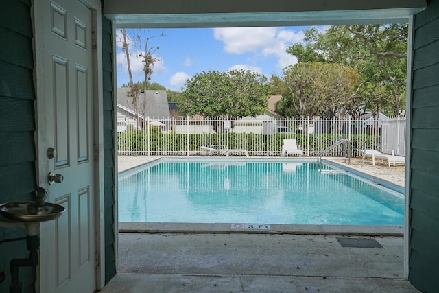 pool with a patio and fence