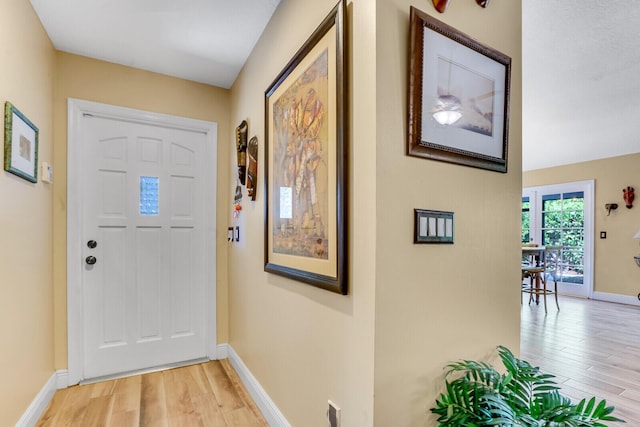 entrance foyer featuring baseboards and light wood finished floors