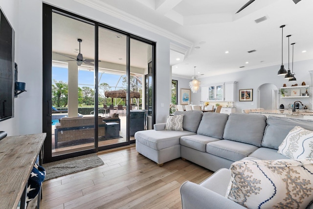 living area with visible vents, a ceiling fan, recessed lighting, arched walkways, and light wood finished floors