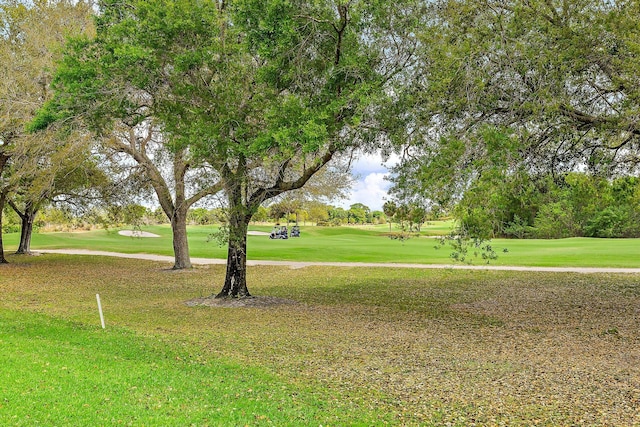 view of home's community with a lawn and view of golf course