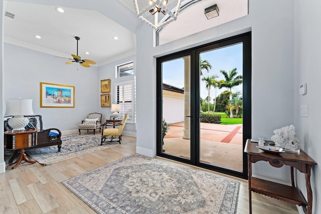 foyer with visible vents, ornamental molding, wood finished floors, an inviting chandelier, and baseboards