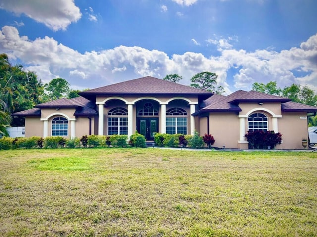 mediterranean / spanish-style home with a front lawn, french doors, and stucco siding