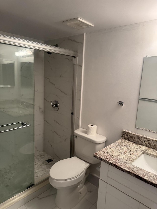 full bathroom featuring toilet, marble finish floor, a marble finish shower, and vanity