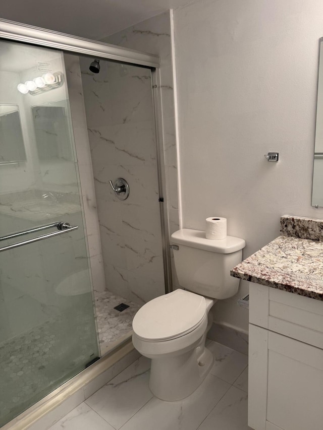 bathroom with marble finish floor, toilet, vanity, and a marble finish shower