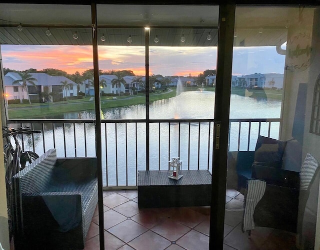 sunroom / solarium featuring a water view and a residential view