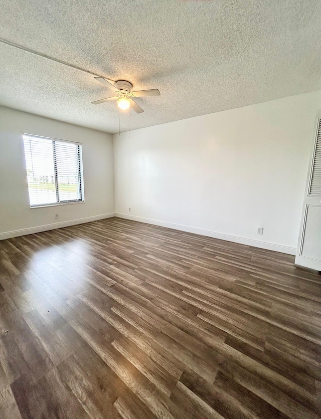 empty room featuring dark wood-style floors, ceiling fan, baseboards, and a textured ceiling