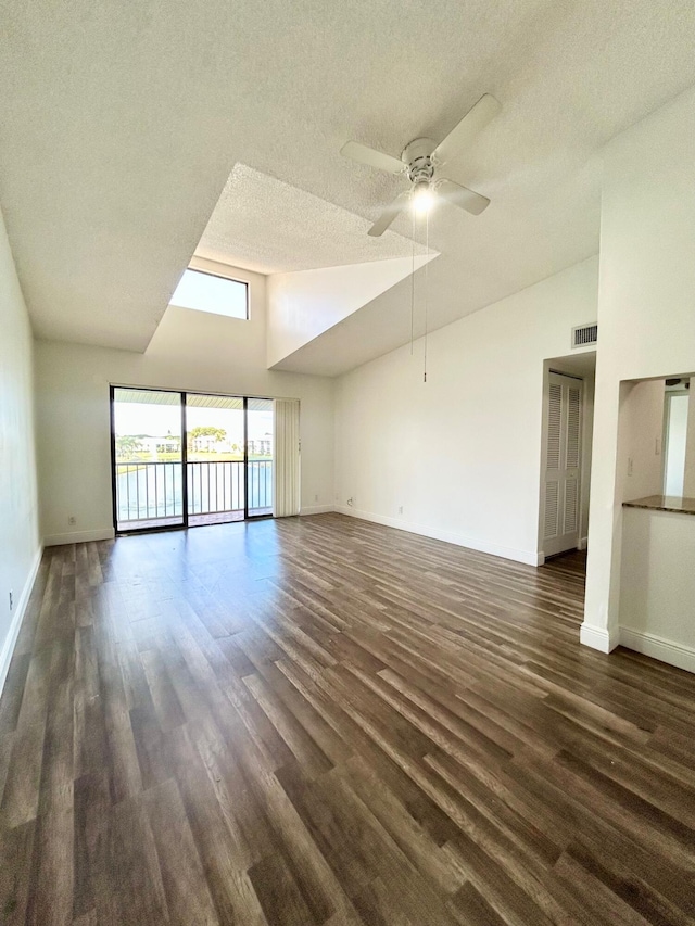 unfurnished living room with ceiling fan, a textured ceiling, dark wood-style flooring, visible vents, and baseboards