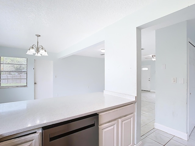 kitchen featuring light stone counters, a chandelier, a textured ceiling, and stainless steel dishwasher