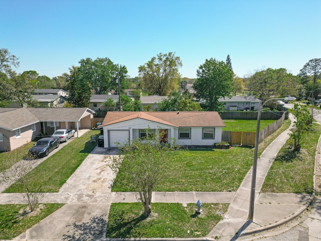 view of front of home featuring a front yard, fence, an attached garage, concrete driveway, and a residential view