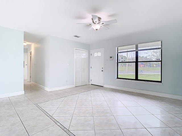 interior space featuring light tile patterned floors, visible vents, baseboards, and ceiling fan