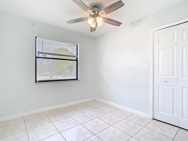 unfurnished room featuring light tile patterned flooring, baseboards, and ceiling fan