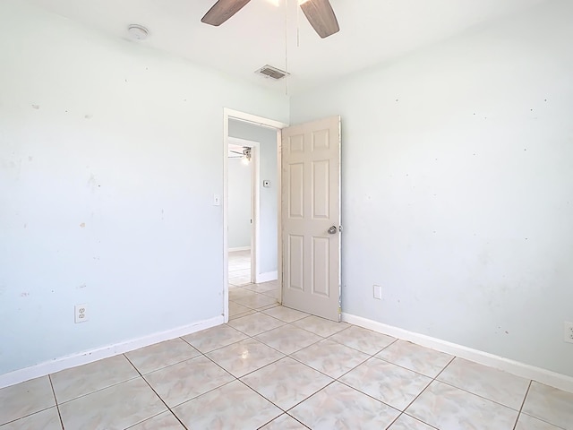 unfurnished room with light tile patterned flooring, visible vents, baseboards, and ceiling fan