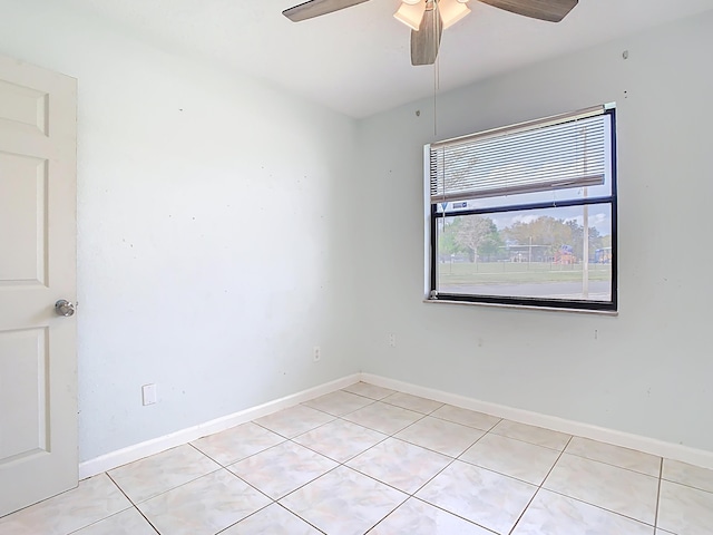 spare room with light tile patterned floors, baseboards, and ceiling fan