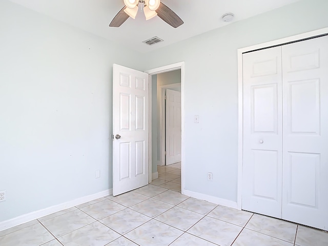 unfurnished bedroom featuring visible vents, baseboards, a closet, and light tile patterned flooring