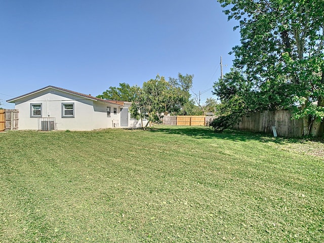 view of yard featuring central AC unit and a fenced backyard