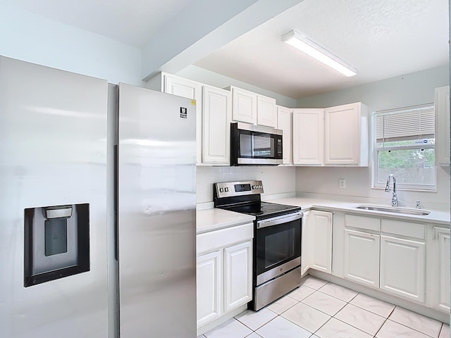 kitchen featuring a sink, stainless steel appliances, white cabinets, and light countertops