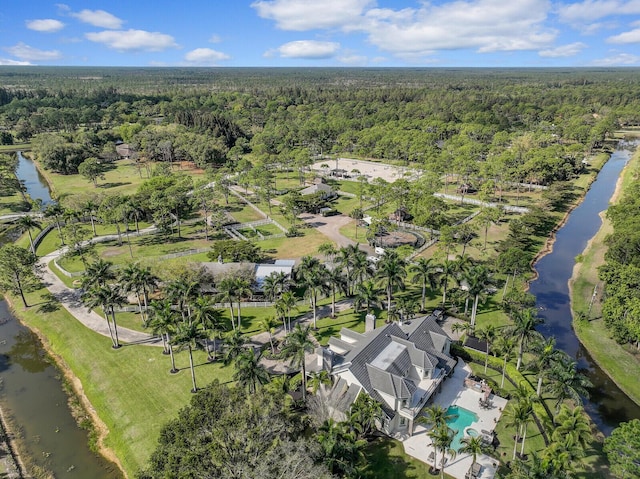 aerial view featuring a forest view and a water view