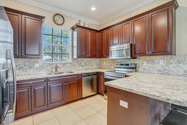 kitchen with light tile patterned flooring, backsplash, appliances with stainless steel finishes, and a sink