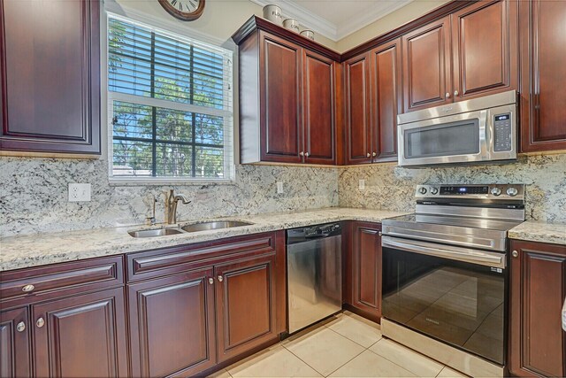 kitchen featuring stainless steel appliances, reddish brown cabinets, a sink, light tile patterned flooring, and light stone countertops