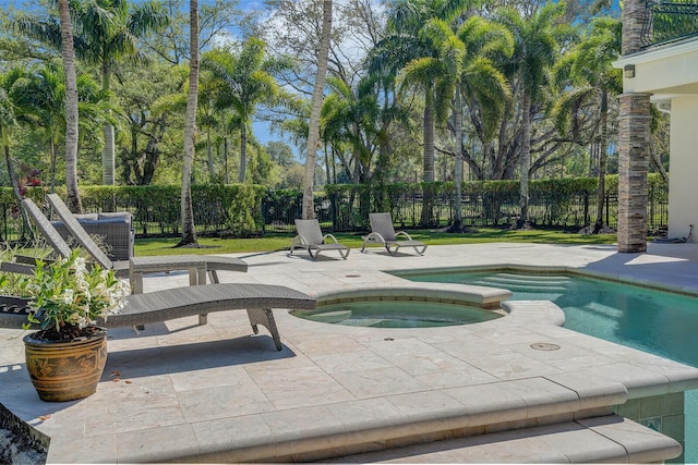 view of pool with a fenced in pool, fence, a patio, and an in ground hot tub