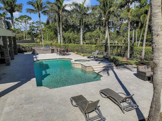 view of pool with a patio area, fence, and a pool with connected hot tub