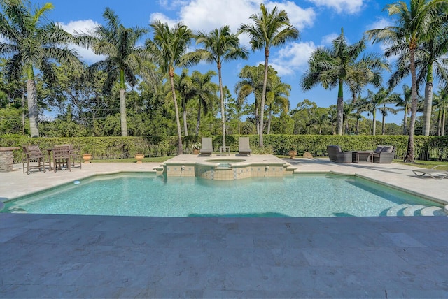 view of swimming pool with a patio, fence, and a pool with connected hot tub