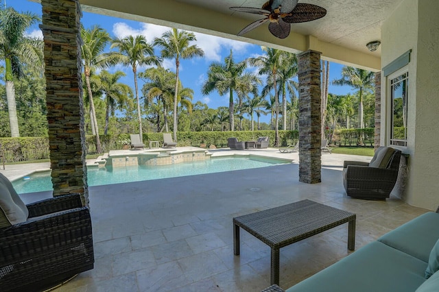 view of pool featuring a patio area, a pool with connected hot tub, and a ceiling fan