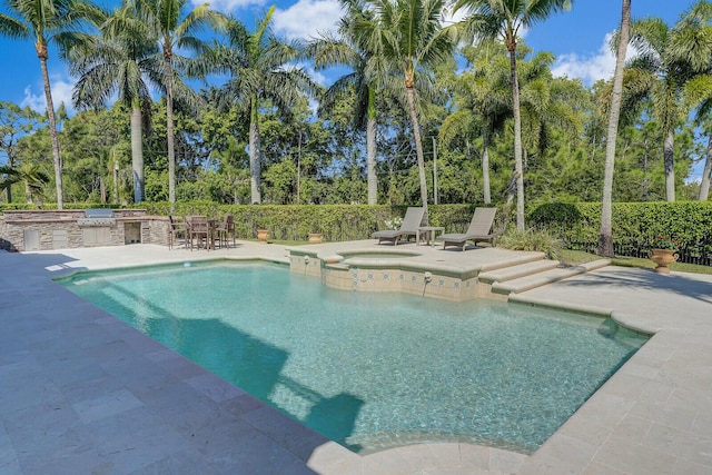 view of swimming pool with a pool with connected hot tub, exterior kitchen, and a patio