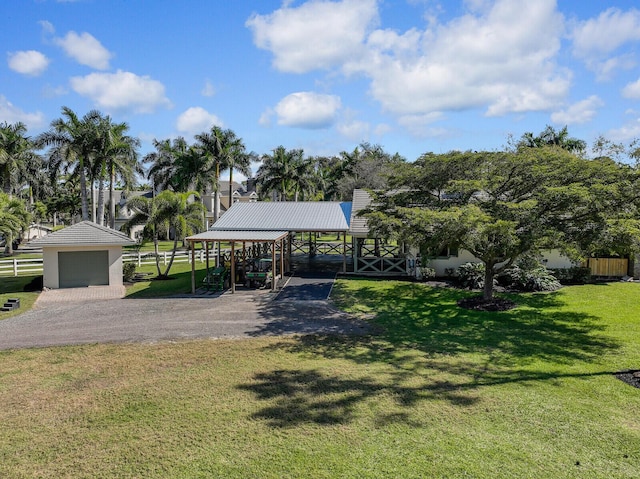 view of property's community featuring a garage, a lawn, and fence