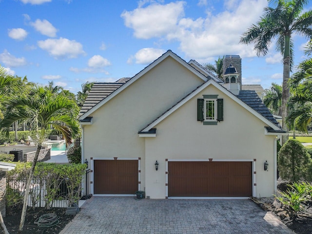 view of home's exterior featuring decorative driveway and stucco siding