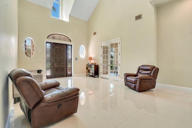 entrance foyer with high vaulted ceiling, french doors, visible vents, and baseboards