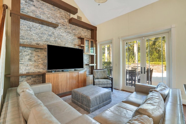 living area featuring high vaulted ceiling, visible vents, and french doors