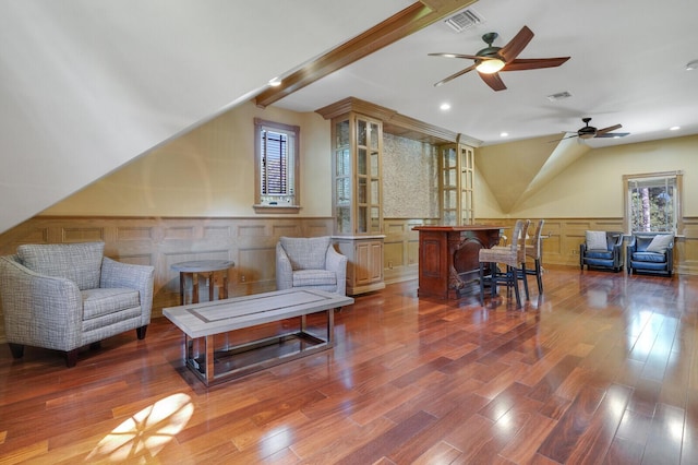 living area with beam ceiling, wood finished floors, and visible vents