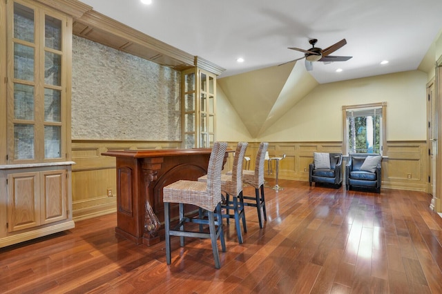 bar featuring a ceiling fan, wainscoting, wood finished floors, a bar, and recessed lighting