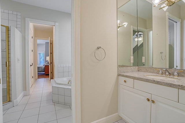 bathroom featuring baseboards, tiled bath, vanity, and tile patterned floors