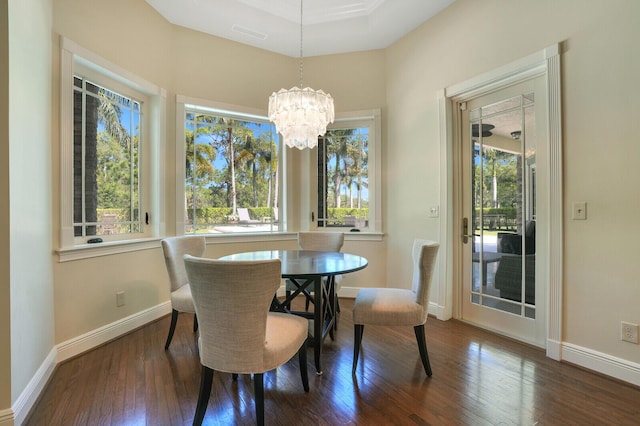 dining space with a notable chandelier, visible vents, baseboards, and hardwood / wood-style floors