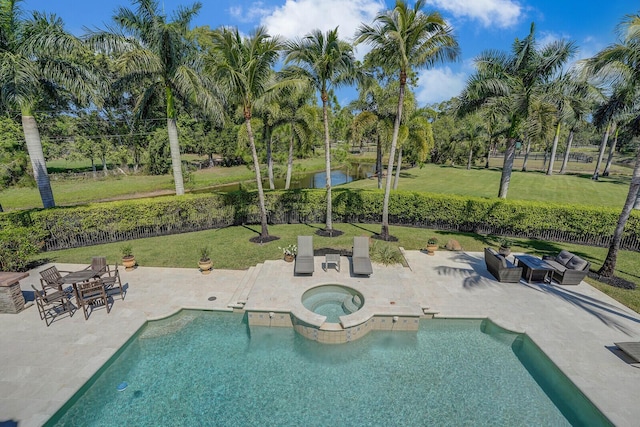 pool with a patio, a yard, a water view, and an in ground hot tub