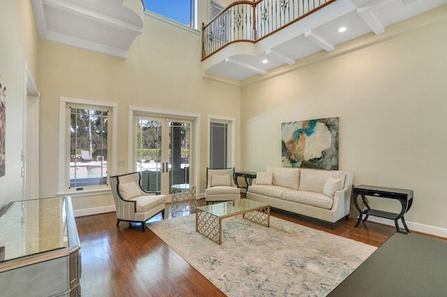 living room featuring french doors, dark wood-type flooring, a high ceiling, and baseboards